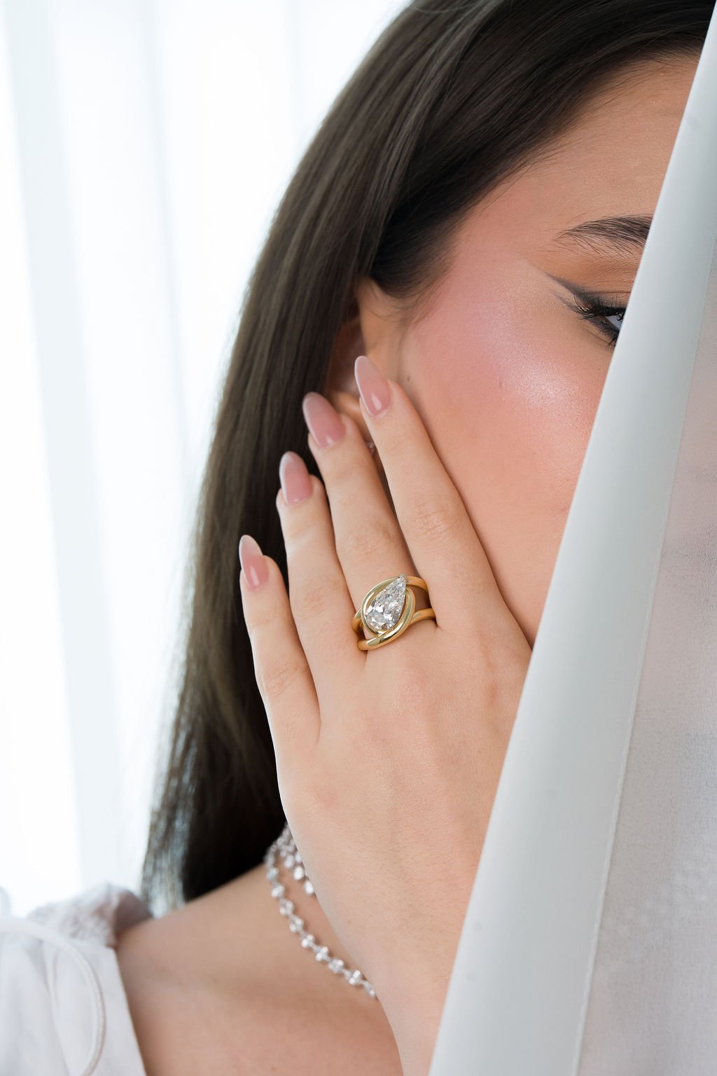 Stellar Gems lab-grown pear diamond ring in yellow gold, modeled close to the face
